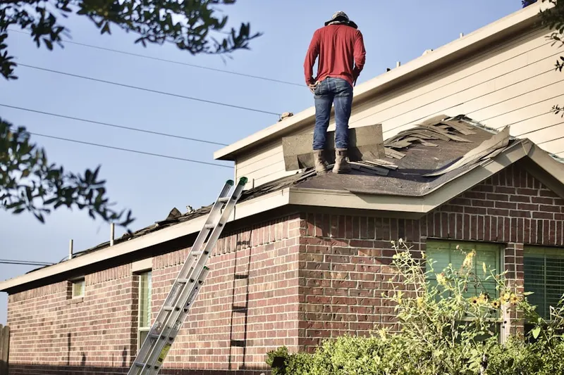Professional roofer working on a residential roof in Penn Brooke Gardens